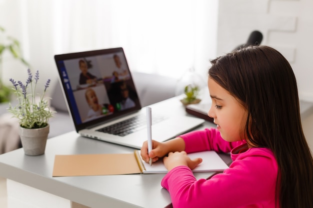 Foto niña estudiando con computadora