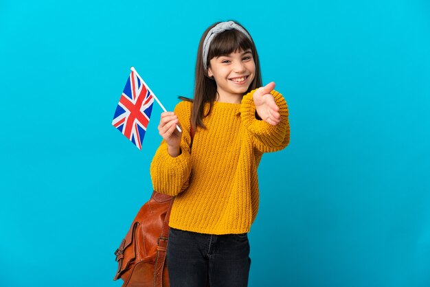 Niña estudiando inglés aislado sobre fondo azul un apretón de manos para cerrar un buen trato