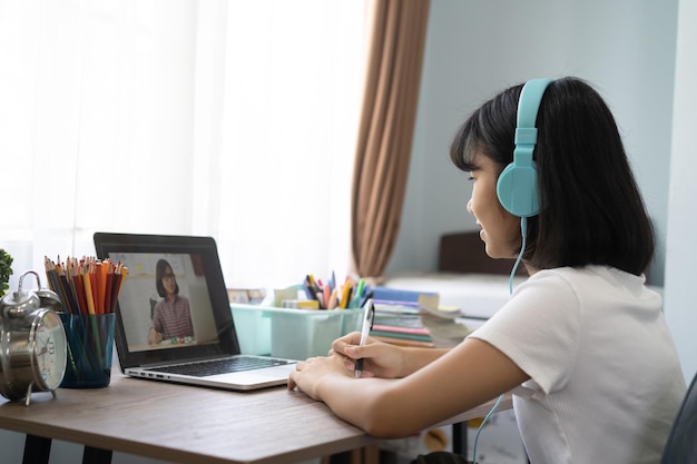 Foto niña estudiando en línea en la computadora portátil en casa