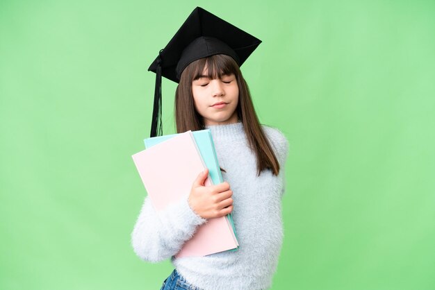 Niña estudiante caucásica sobre un fondo aislado que sufre de dolor de espalda por haber hecho un esfuerzo