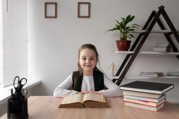 Niña estudiante que estudia la tarea durante las lecciones en línea en casa El niño sonríe y se ríe mirando la cámara Vista desde la cámara web Educación en línea a distancia