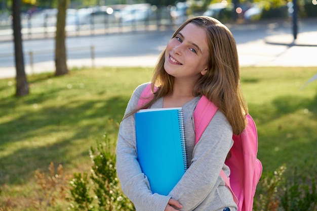 Niña estudiante rubia en la ciudad.