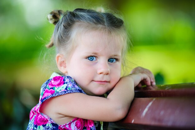 Niña europea divirtiéndose y posa en el patio de recreo en verano.