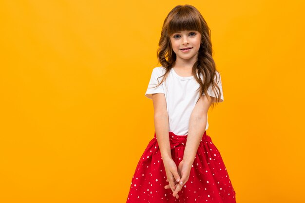 niña en una falda posando en amarillo