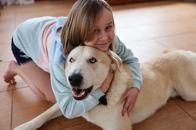 Niña feliz abraza a un perro grande