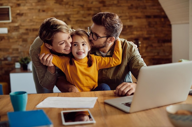 Niña feliz abrazando a sus padres en casa