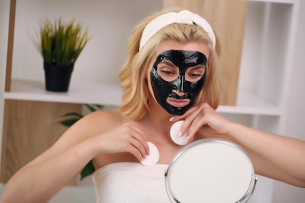 Foto niña feliz aplicando mascarilla facial mujer joven que tiene un día de spa para el cuidado de la piel día de tratamiento limpio de belleza y concepto de productos de cosmetología