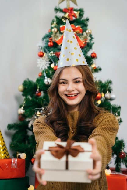 Niña feliz asiática y decorar el árbol de Navidad Mujeres jóvenes para celebrar la fiesta de acción de gracias de Navidad en la sala de estar en casa