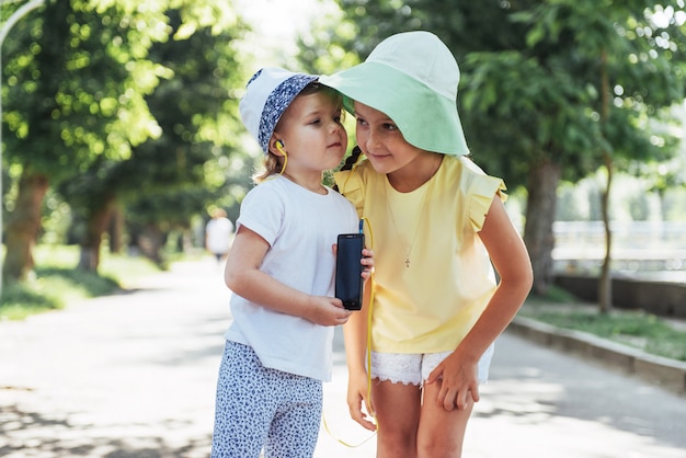 Niña feliz con auriculares para compartir música