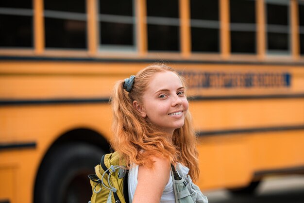 Niña feliz en el autobús escolar emocionado por el primer día de clases. Adolescente de la escuela feliz. Educación.