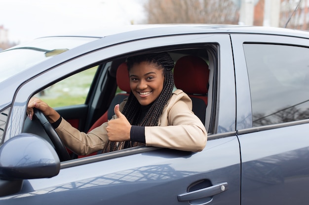 La niña feliz en un automóvil, afroamericano