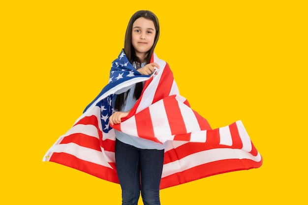 niña feliz con la bandera de los Estados Unidos de América EE.UU. sobre fondo de color amarillo.