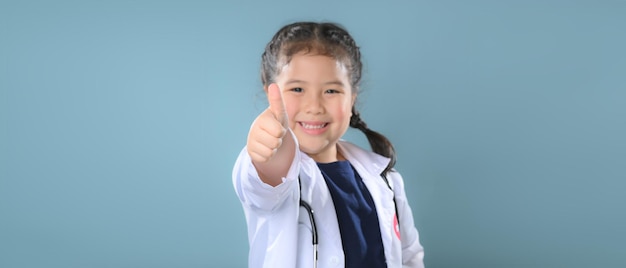 Foto niña feliz en bata de médico con estetoscopio. niño jugando. ocupación futura o concepto de trabajo soñado. feliz día del niño.