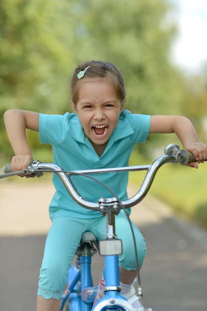 Foto niña feliz en bicicleta en verano