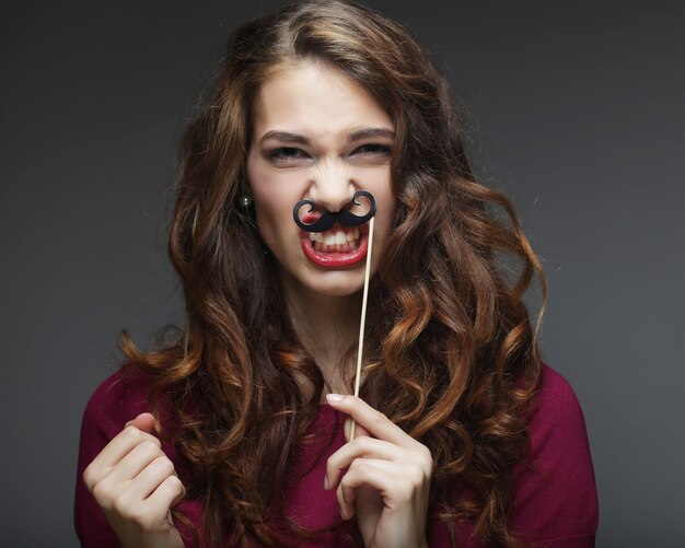 Niña feliz con bigote falso