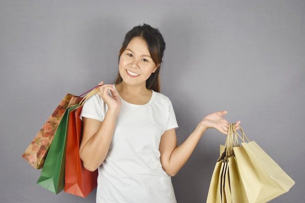 niña feliz con bolsa de compras de moda en gris.