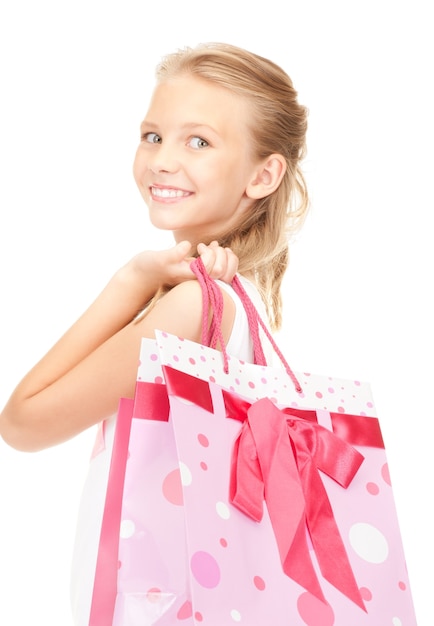 niña feliz con bolsas de la compra sobre blanco