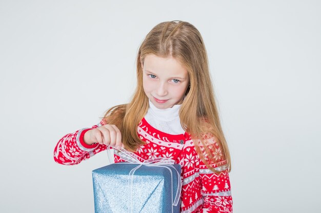 niña feliz con caja abierta de pelo largo con regalo de navidad