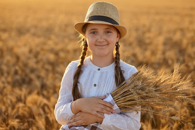 Niña feliz caminando en trigo dorado, disfrutando de la vida en el campo.