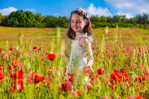 Niña feliz en el campo de flores en verano