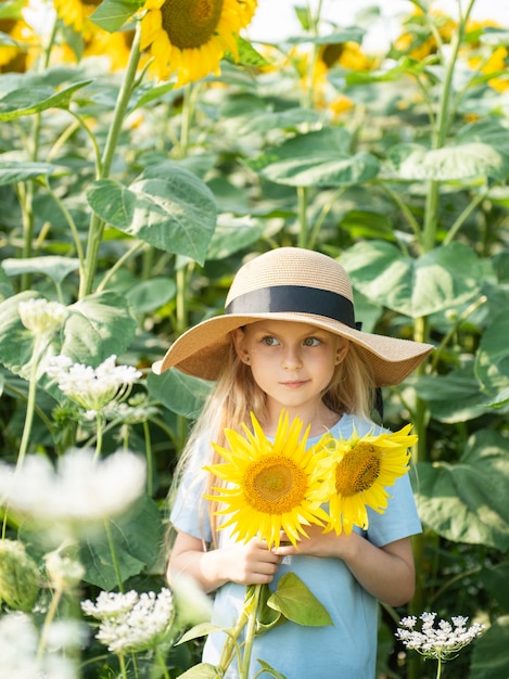 Foto niña feliz en el campo de girasoles en verano.