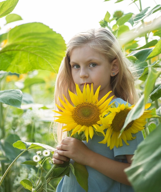 Niña feliz en el campo de girasoles en verano.