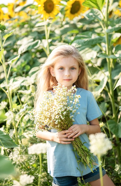 Niña feliz en el campo de girasoles en verano.