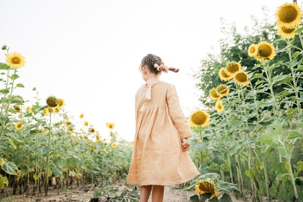 Niña feliz en el campo de los girasoles.