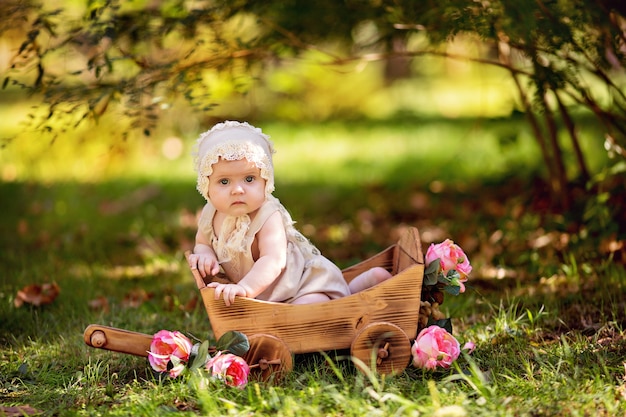 Niña feliz en un carro con flores rosas