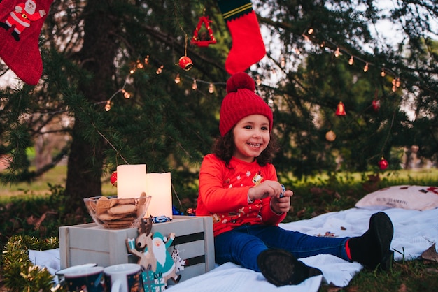 Niña feliz celebrando la navidad con luces y elementos navideños