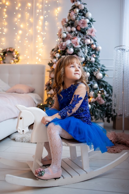 Niña feliz cerca del árbol de Navidad