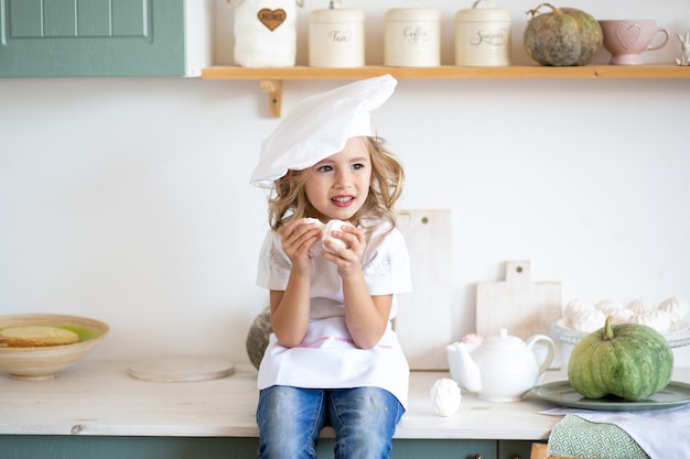 Niña feliz chef jugando en la cocina en casa