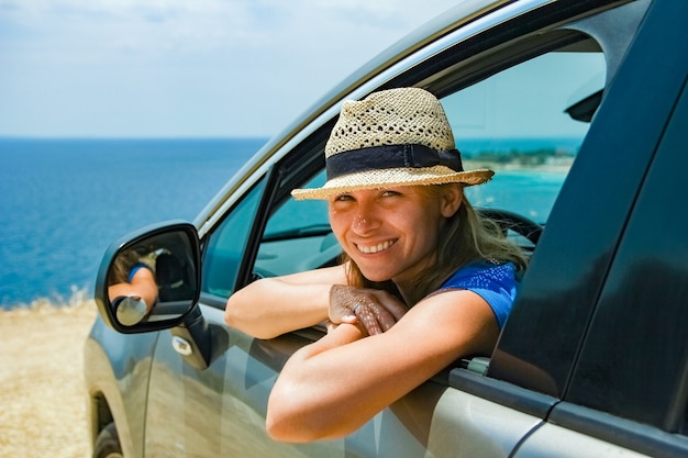 Una niña feliz del coche en el mar.