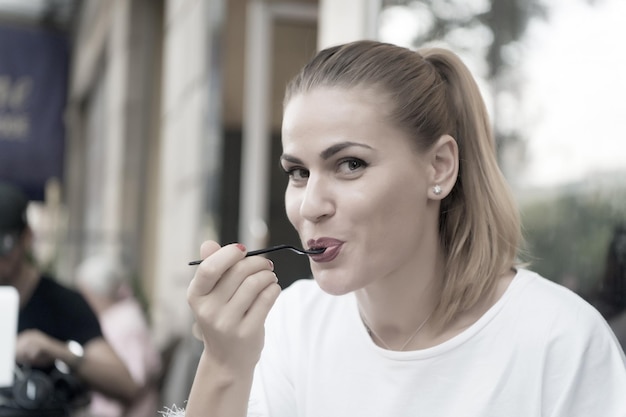 Niña feliz come con tenedor en café en parís, francia. Hambre, concepto de apetito. Comida, merienda, comer.