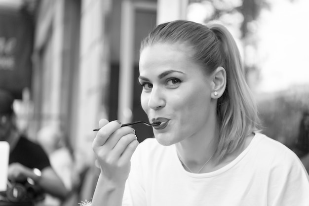 Niña feliz comer con tenedor en café en parís francia