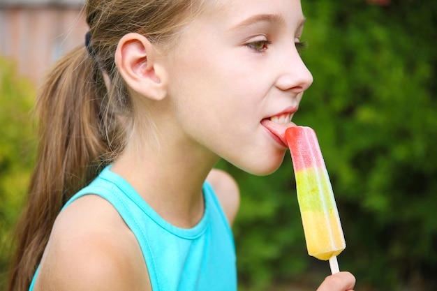 Niña feliz comiendo helado.