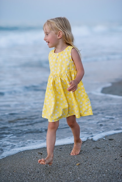 Niña feliz corriendo y saltando en la playa