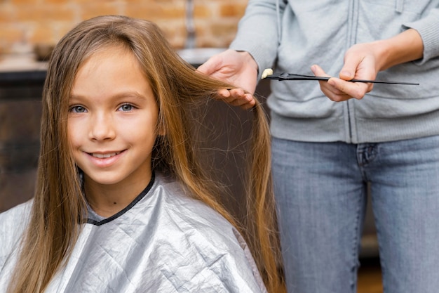 Foto niña feliz cortándose el pelo