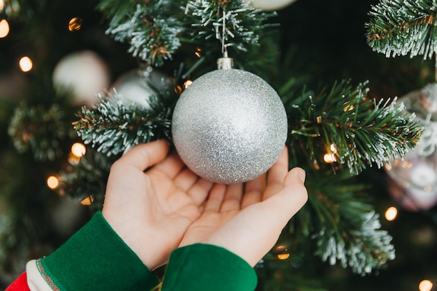 Niña feliz decorar el árbol de Navidad en casa. vacaciones de invierno y concepto de personas