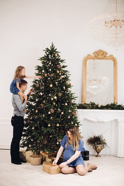 Niña feliz decorar el árbol de Navidad en casa