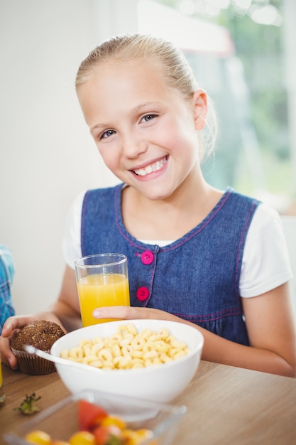 Niña feliz desayunando por mesa