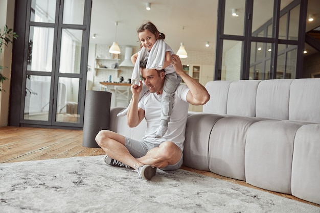 Niña feliz disfrutando de tiempo con papá en casa