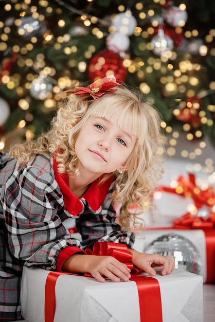 Niña feliz emocionada con caja de regalo de Navidad.