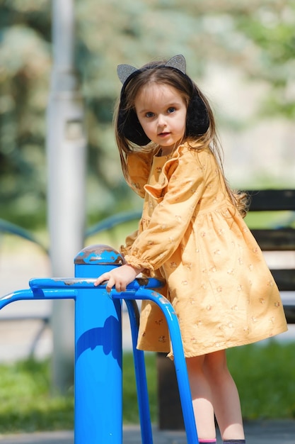 Niña feliz está jugando en el patio de recreo en el parque