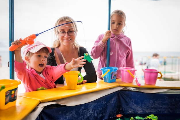 Niña feliz con la familia jugando en la pesca. Niños jugando afuera