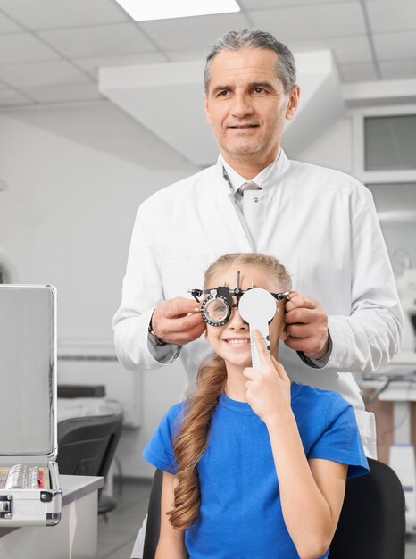 Niña feliz con gafas con lente para controlar la visión