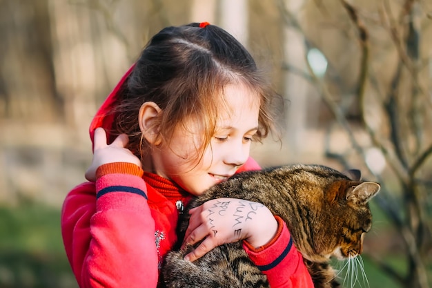 Niña feliz con un gato al aire libre