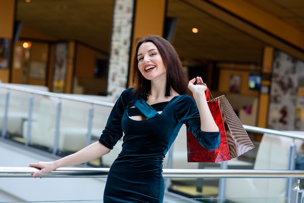 Niña feliz hace una compra en el centro comercial.