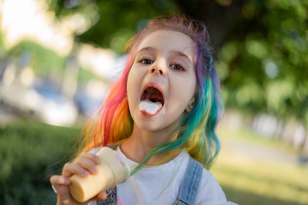 Niña feliz con helado al aire libre. Imagen con enfoque selectivo