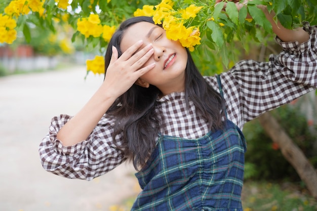 Niña feliz con hermosa flor amarilla.